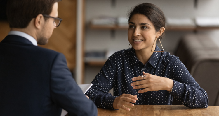 A young Indian woman talks with a male employee during a hiring interview